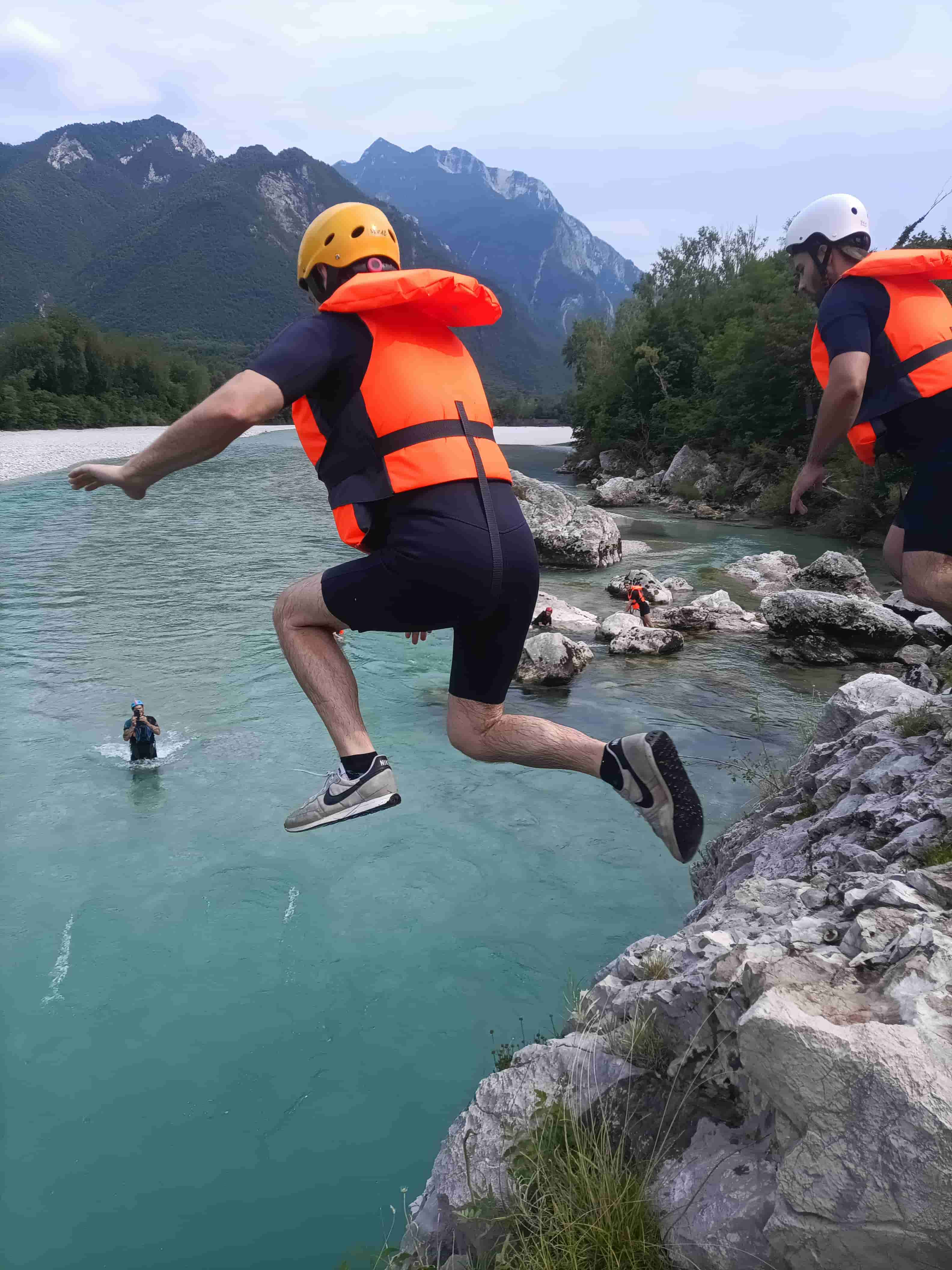 Gruppo di amici che si tuffa dalle rocce nel Fiume Tagliamento. Attività estiva e divertimento outdoor con la scuola kayak friuli a Venzone